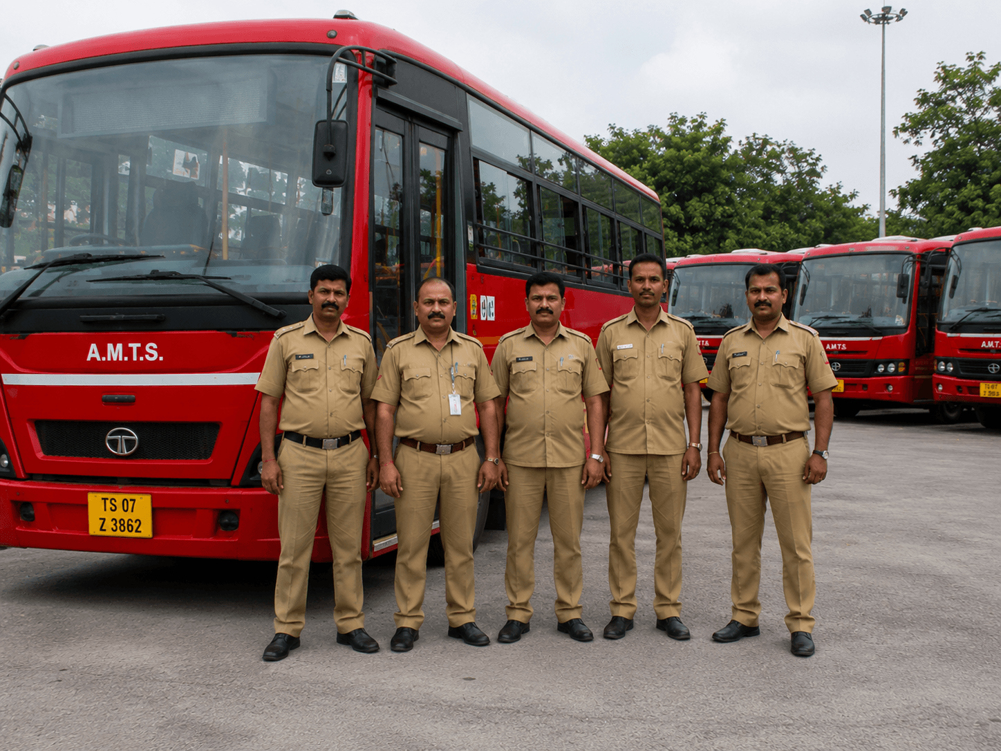 A group of Shree Translink drivers in matching uniforms standing in front of their buses